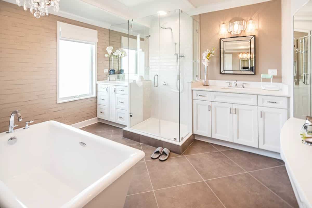 Bathroom with chandelier, oatmeal painted walls and square mirrors