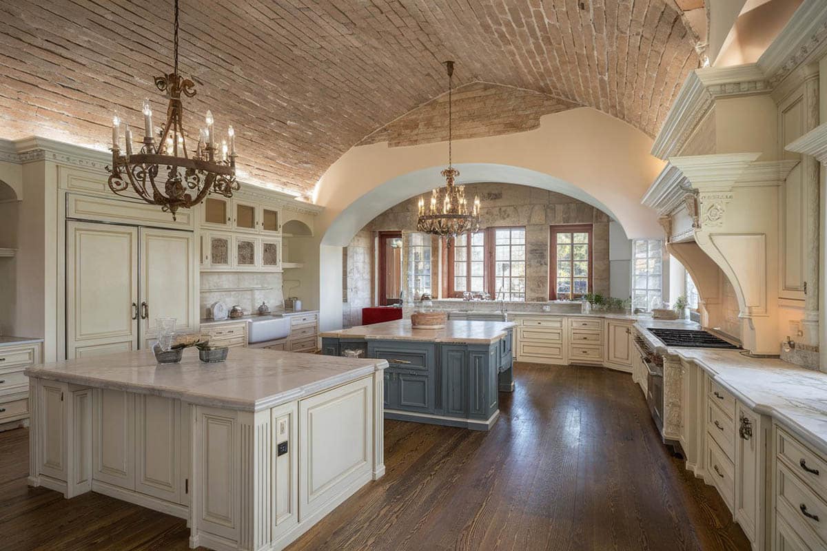 Kitchen with arched brick ceiling, off white cabinetry and crystal chandeliers
