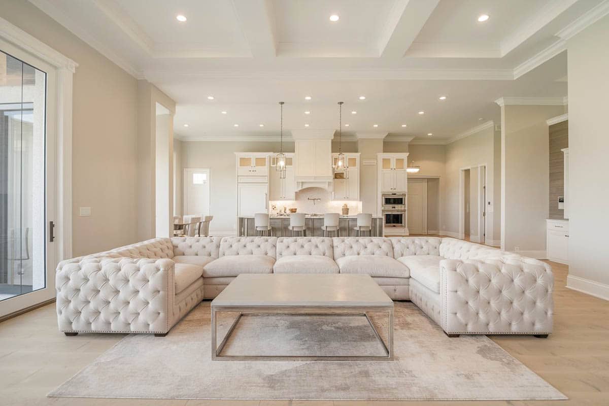 Room with tufted wraparound sectional and large format floor tiles