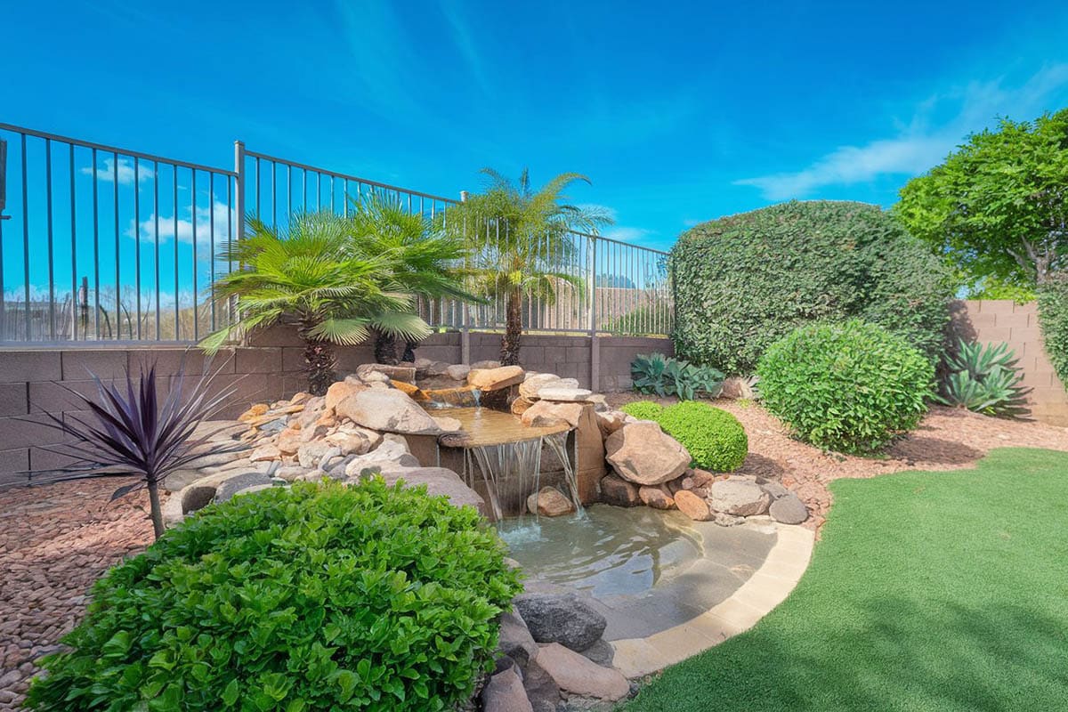 Garden waterfall and small pond in landscaped backyard