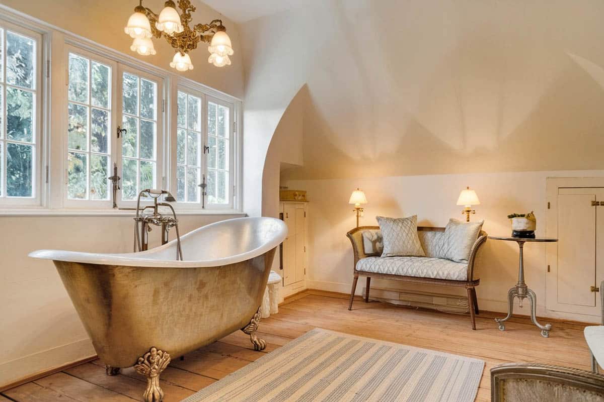 Master bathroom with aged chrome bathtub, loveseat and carpet