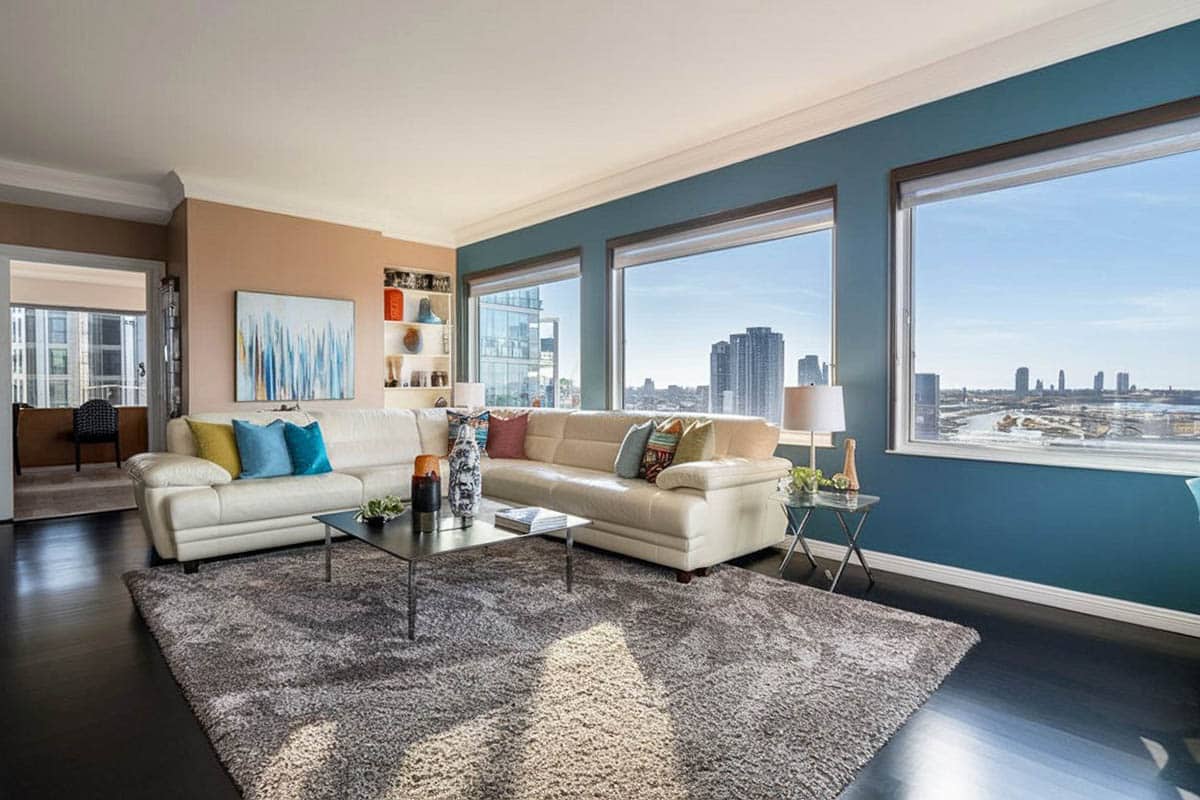 Modern living room with blue wall and beige, with picture window views of city
