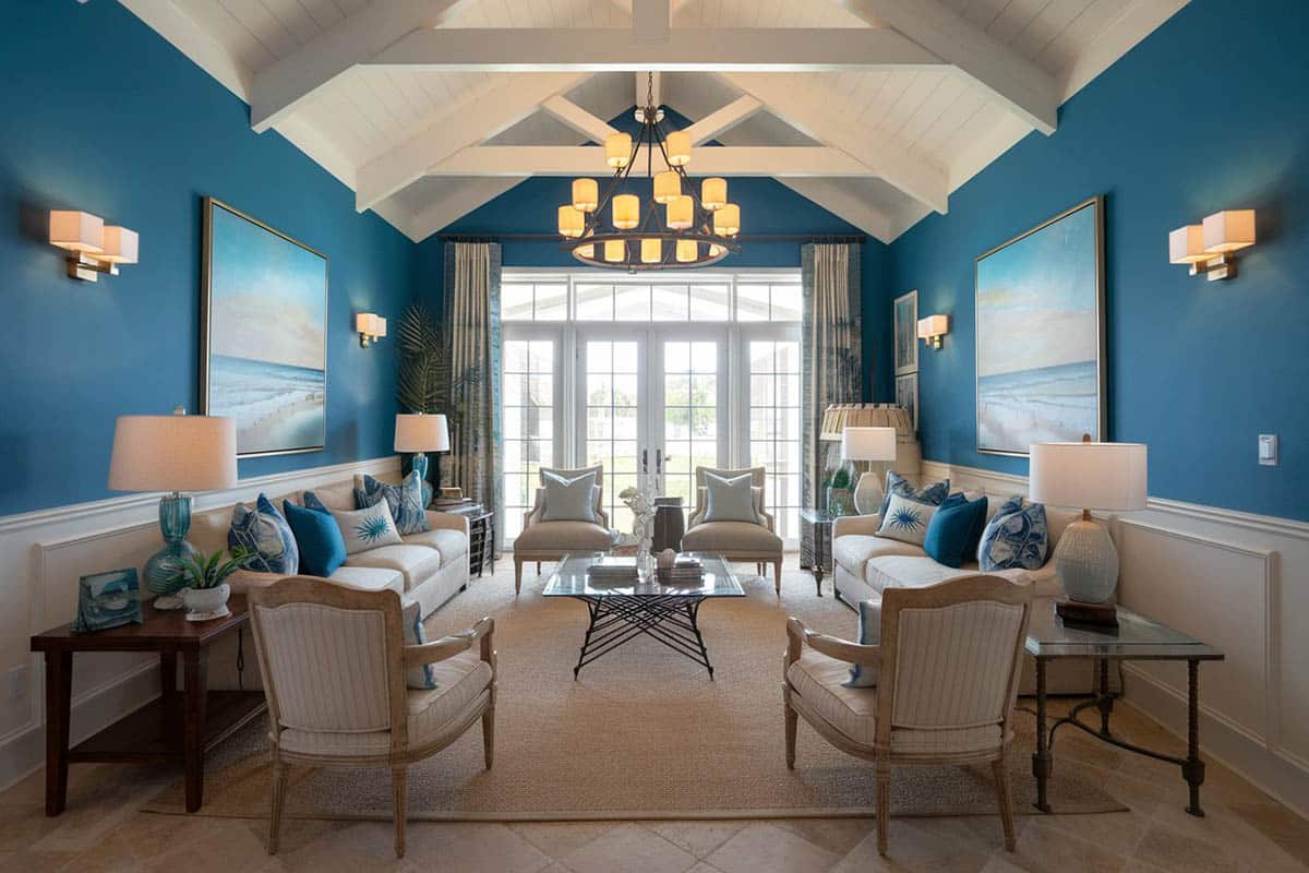 Nautical blue themed formal room with white wainscoting, chandelier and vaulted ceiling