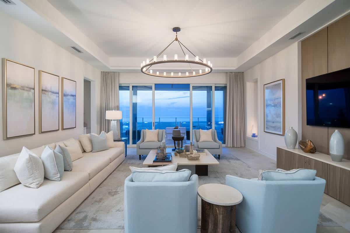 Modern coastal style sofa with wagon wheel chandelier and tray ceiling