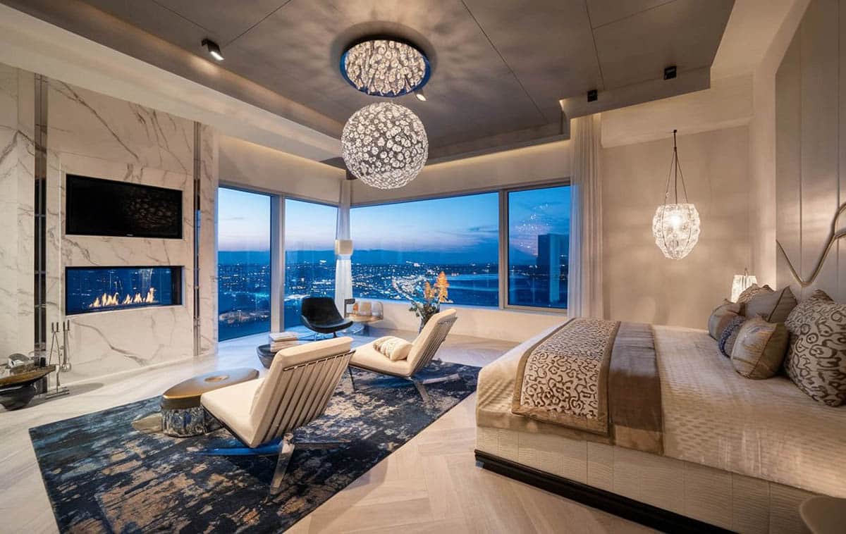 bedroom with modern globe chandelier, fireplace and amazing views
