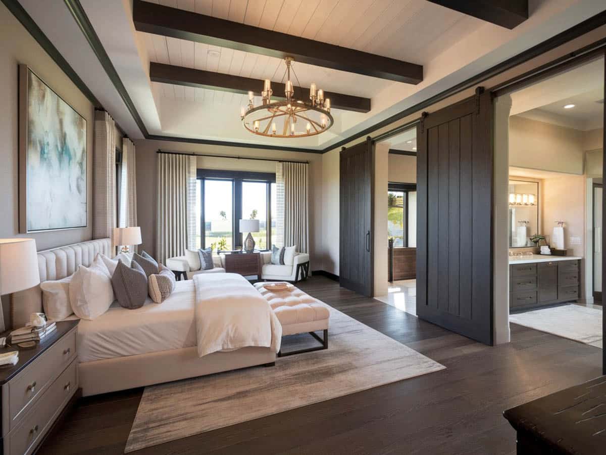 Luxury Mediterranean style bedroom with wide plank wood flooring and exposed wood beams
