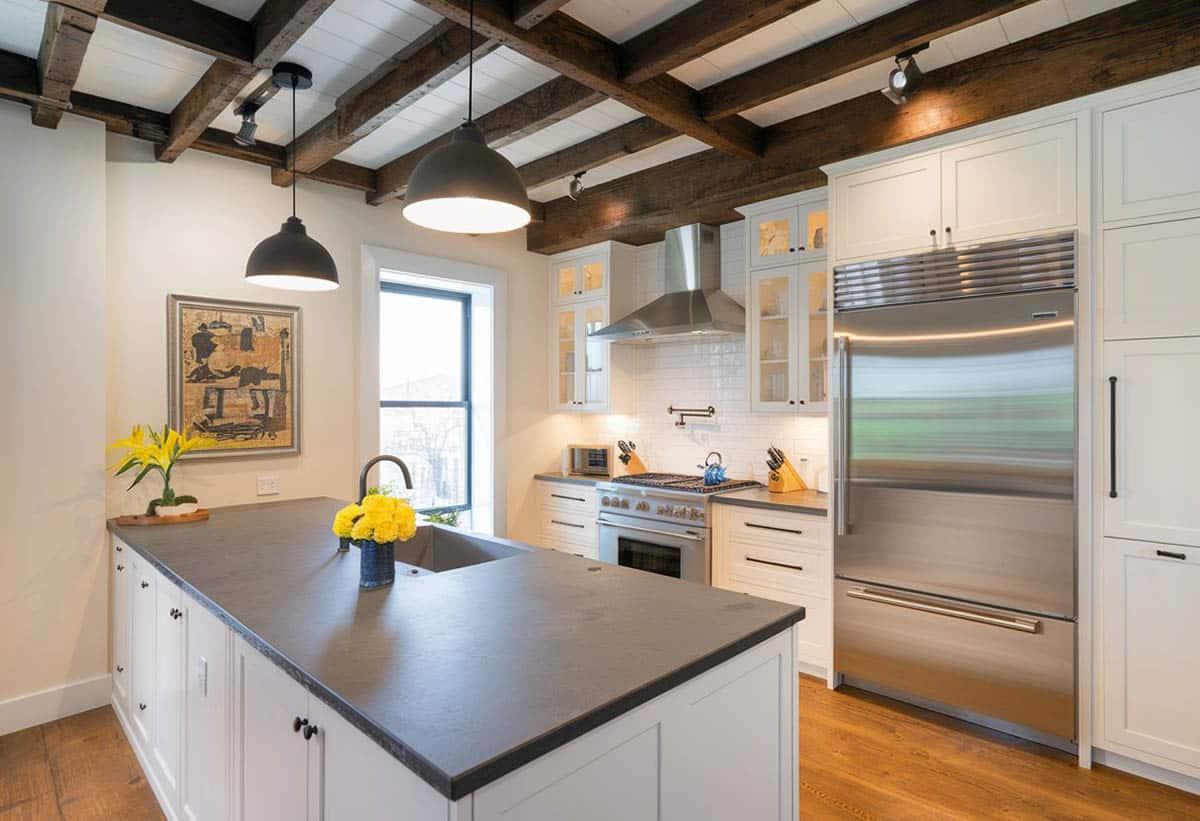 Contemporary kitchen with peninsula soapstone counters, exposed beams and white shaker cabinets