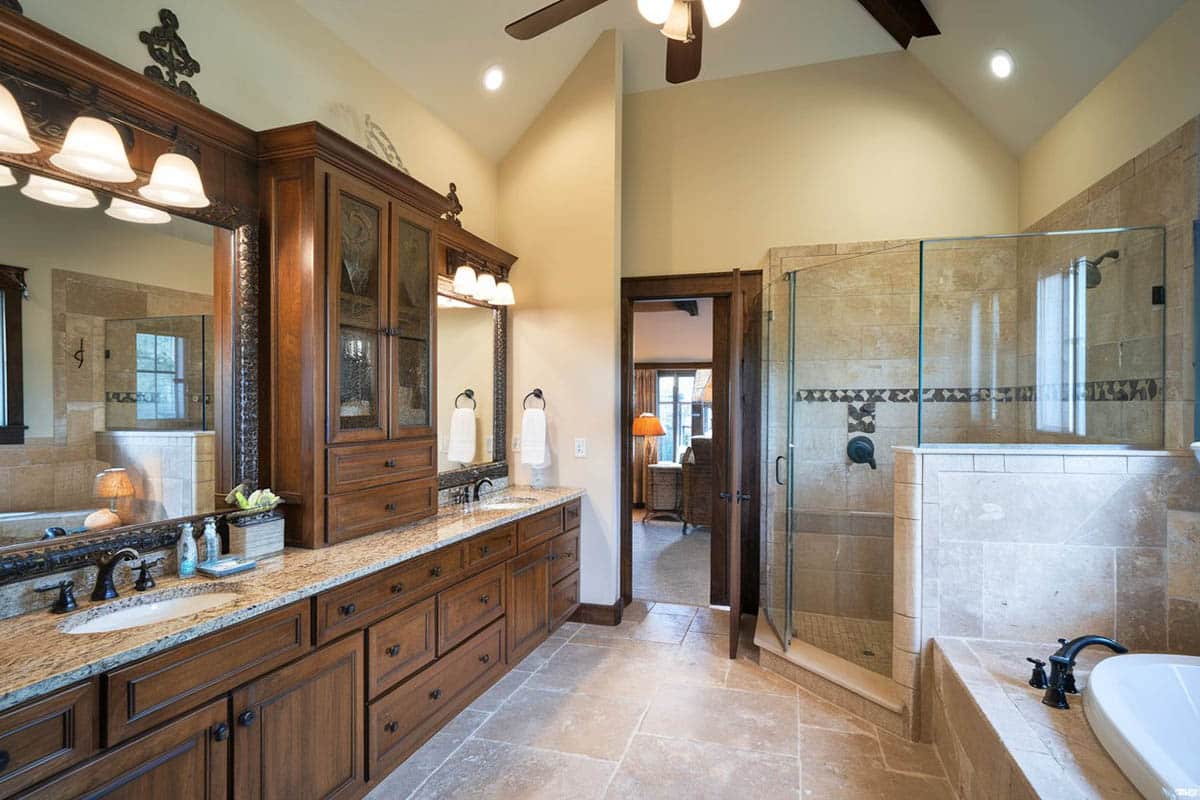 Bathroom with granite counter with walnut vanity base and natural stone tiles