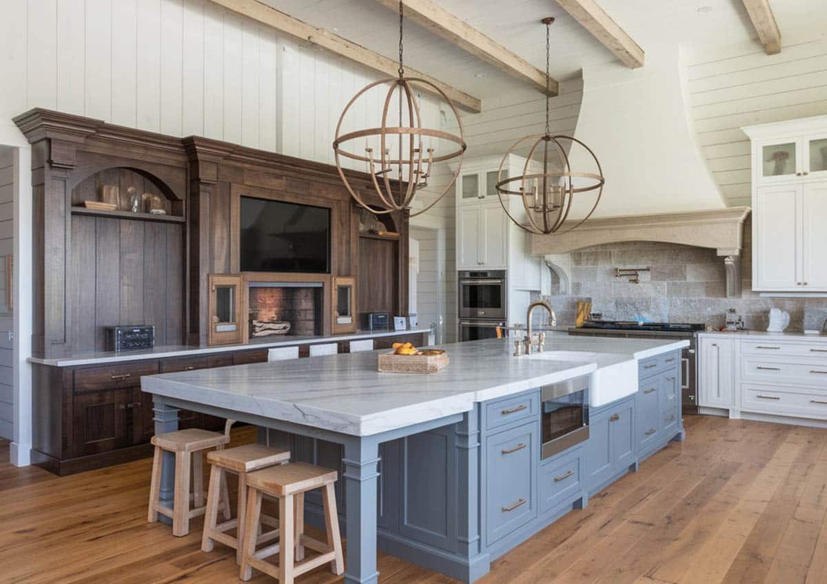 Kitchen with white cabinets, hardwood floors, gray island and bianco venatino marble surface