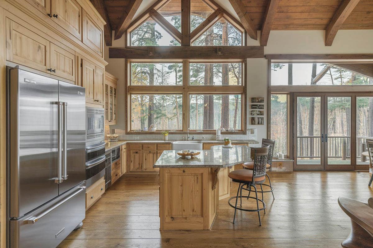 Kitchen with large windows, exposed rafters and cabinets with hickory
