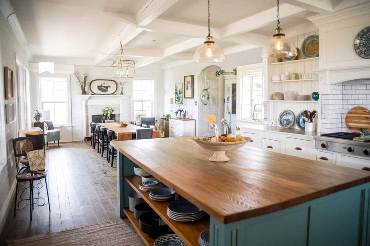 Country kitchen with green distressed wood island with wood countertop, plank hardwood flooring and ceramic tile backsplash
