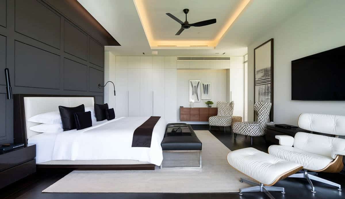 Modern bedroom with padded black accent wall and black decor