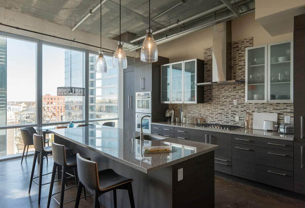 Industrial style kitchen with concrete floors and glass front cabinets