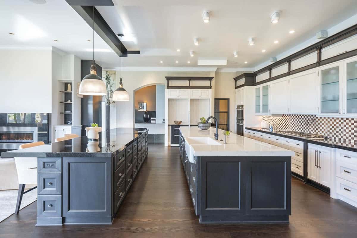 Transitional kitchen with two islands with black cabinets and main white cabinets with agatha black granite and arctic white quartz