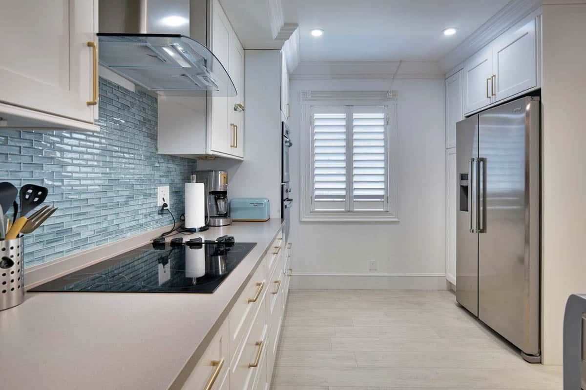Kitchen with blue glass backsplash and gray solid surface countertops
