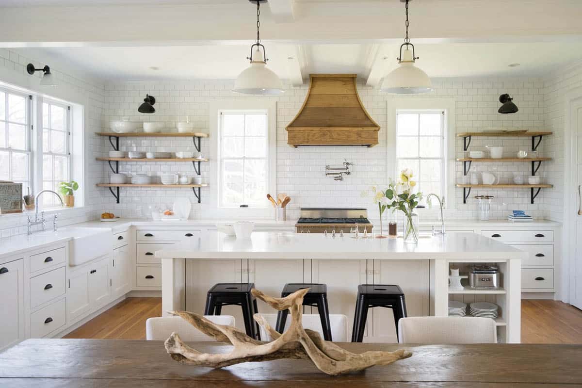 Kitchen with white cabinets, white tile backsplash and long breakfast bar island