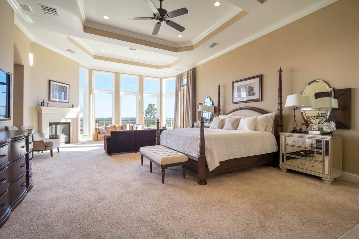 Room with four poster bed and tufted fabric bench
