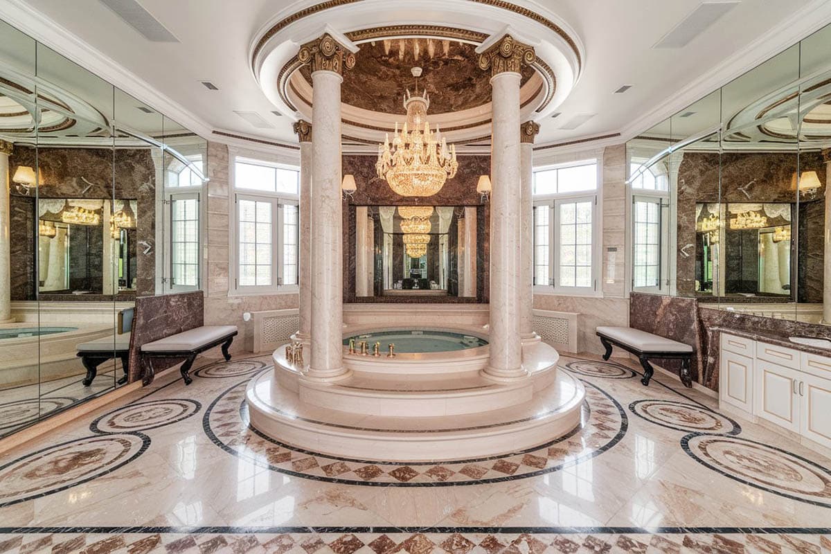 Amazing mansion with high-ceiling bathroom with pillars, central tub and chandelier