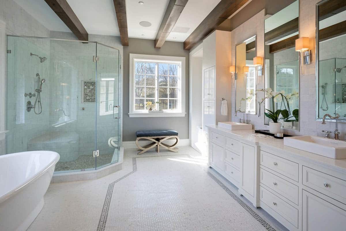 Bathroom with exposed beam ceiling, stone pebble floors, soaking tub and vessel sinks