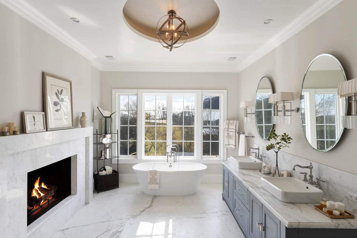 bathroom with fireplace, freestanding tub, porcelain floors and ball chandelier