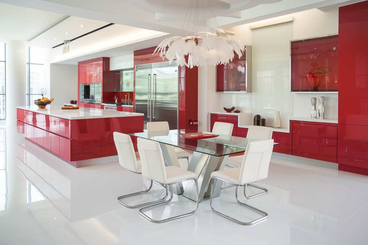 Red modern kitchen with white corian countertop and feather pendant lights