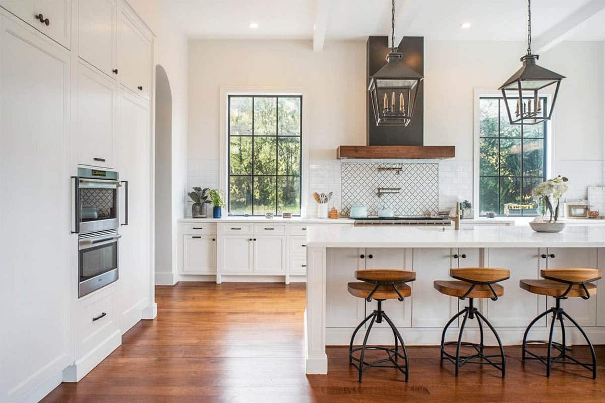 Large chefs kitchen with white cabinetry and breakfast bar seating