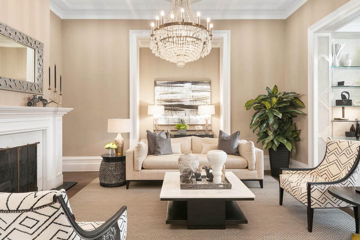 Chandelier, fireplace, textured sofa seats set in white room