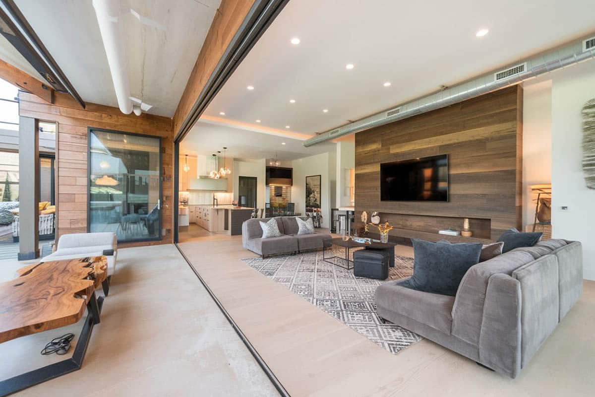 Light gray floors made of concrete, accent panel walls made of teak and armless sofas