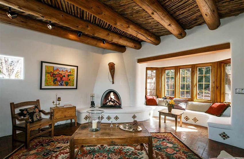 Rustic spanish room with cement fireplace and large round wood log beams