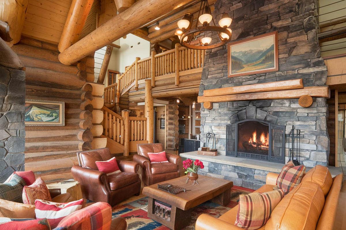 Rustic room in log cabin home with stone built fireplace
