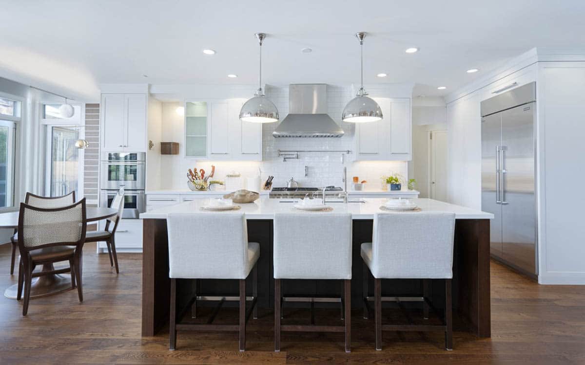 White contemporary kitchen with calcatta marble countertops, dark wood island and hardwood floors