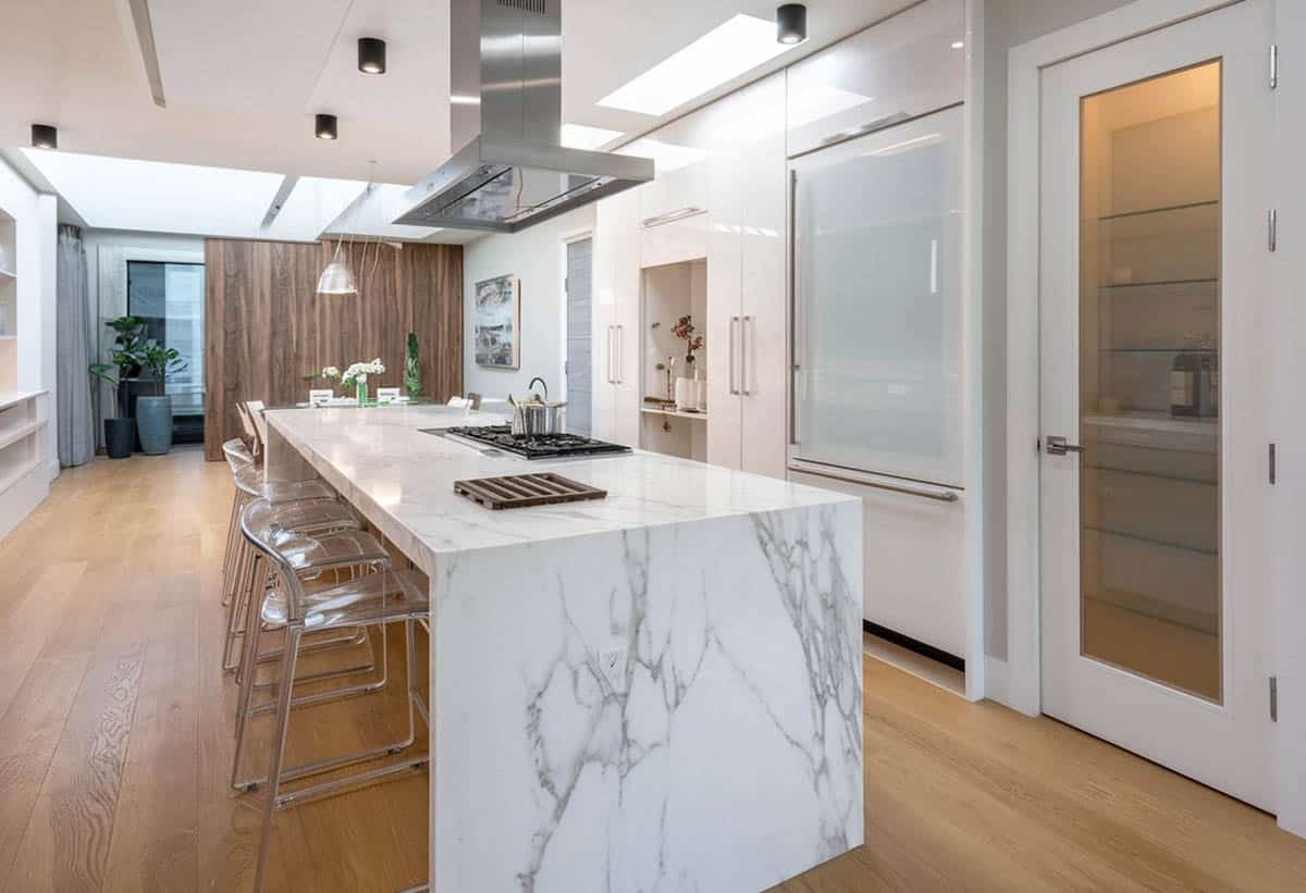 Kitchen with waterfall island, European cabinets and glass door