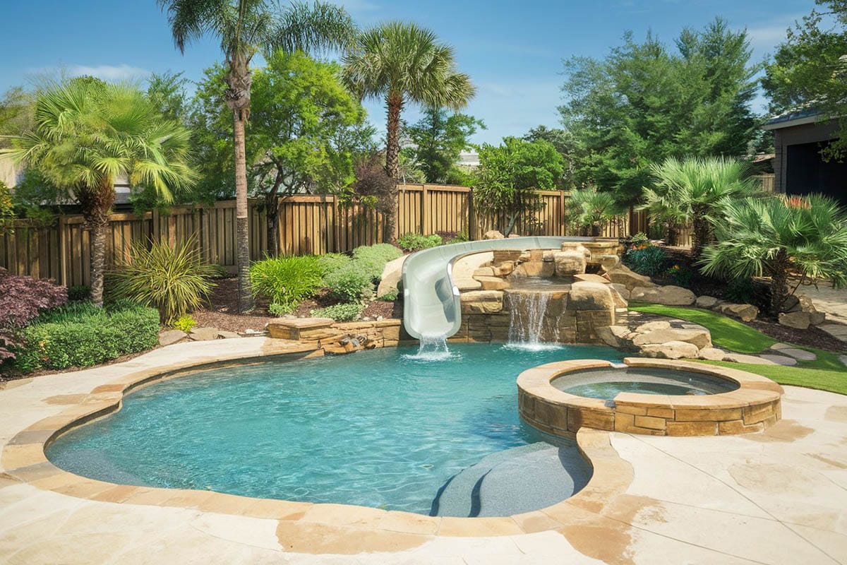 Freeform pool with rock water, slide and elevated tub