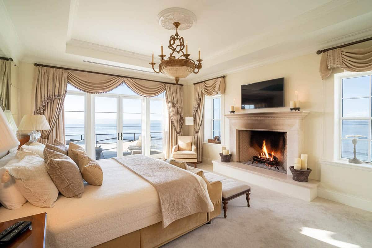 Traditional created bedroom with elegant fireplace ocean views and balcony