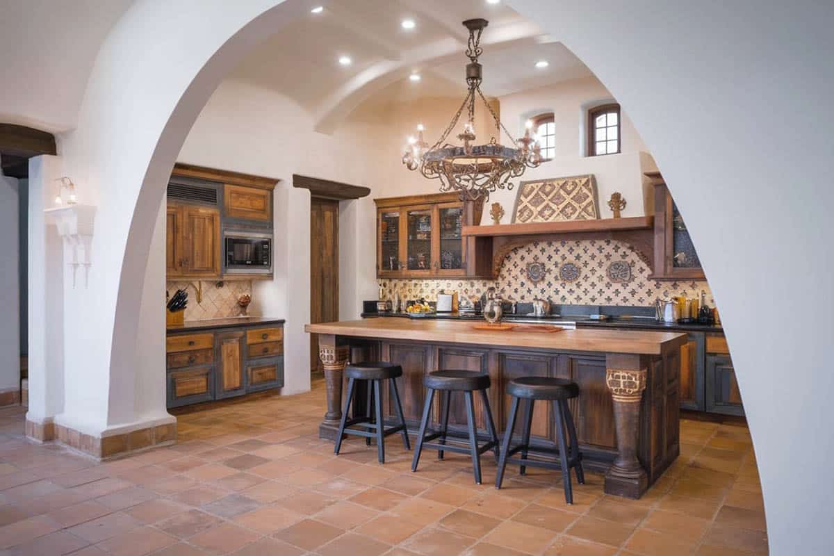 Kitchen with high ceiling, black island and arched doorway