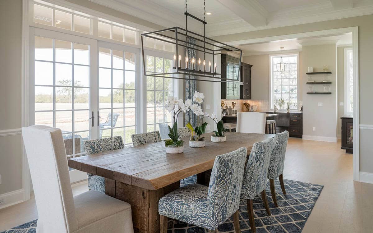 Room with upholstered chairs, floor to ceiling windows and candle chandeliers