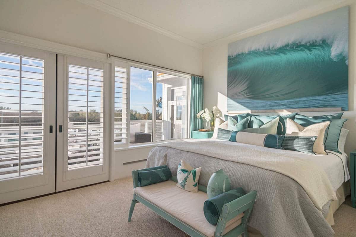 Bedroom with ocean wall art, teal bed covers and white plantation shutters