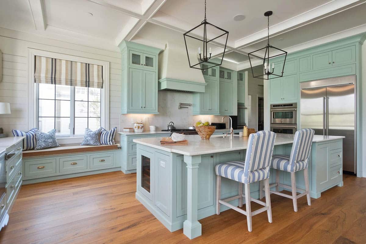 Kitchen with seafoam green cabinetry, white granite island and window seat
