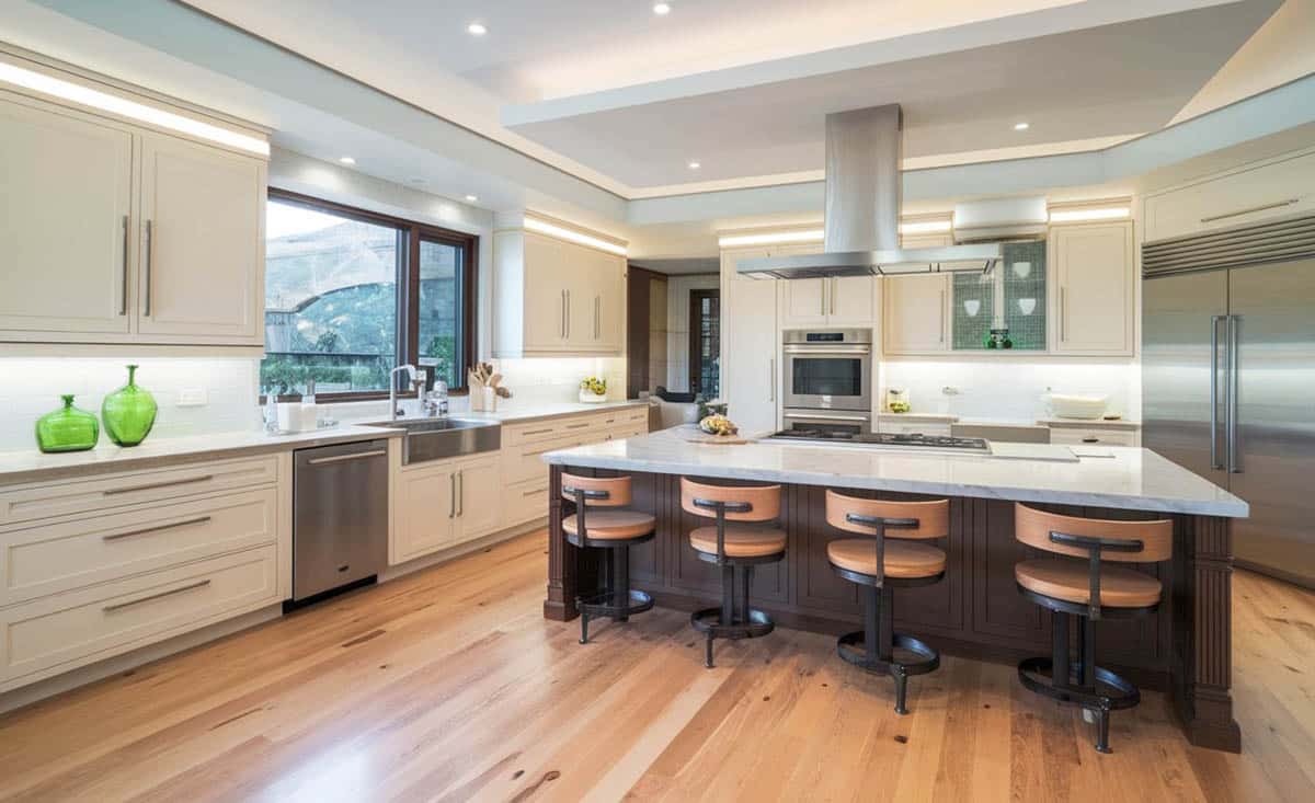 Contemporary kitchen with open concept design, white cabinetry, white quartz and black quartz countertops