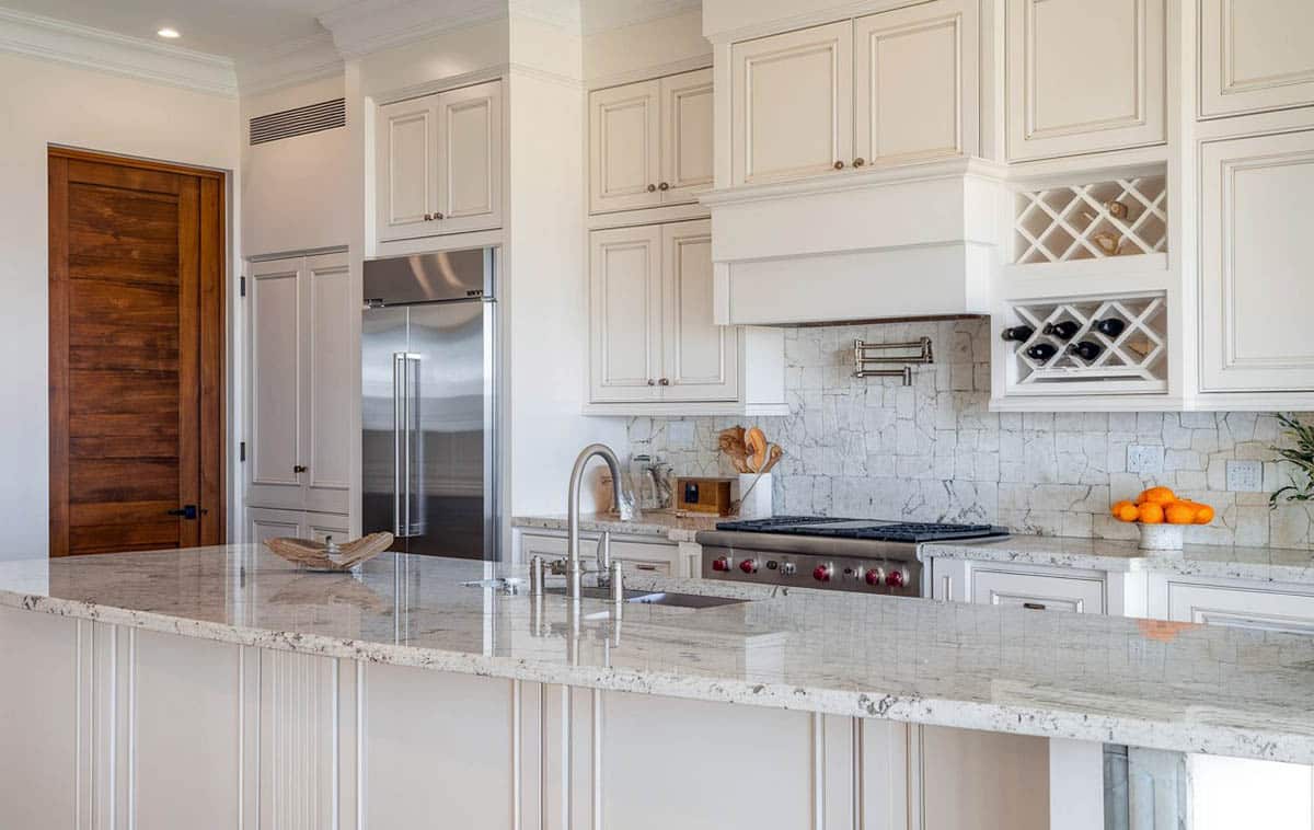 Kitchen with white alpha granite slab countertops with white raised panel cabinets