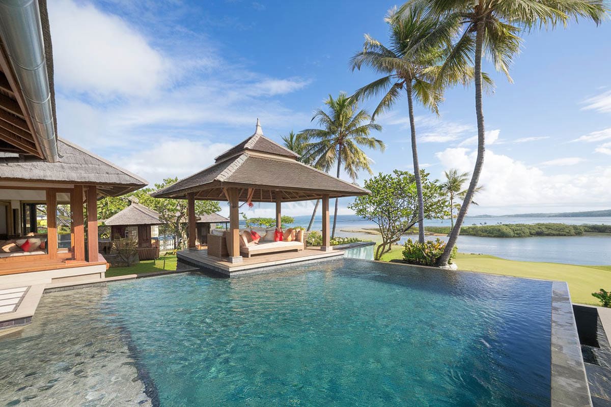 Wooden pavilion with coconut trees and infinity pool