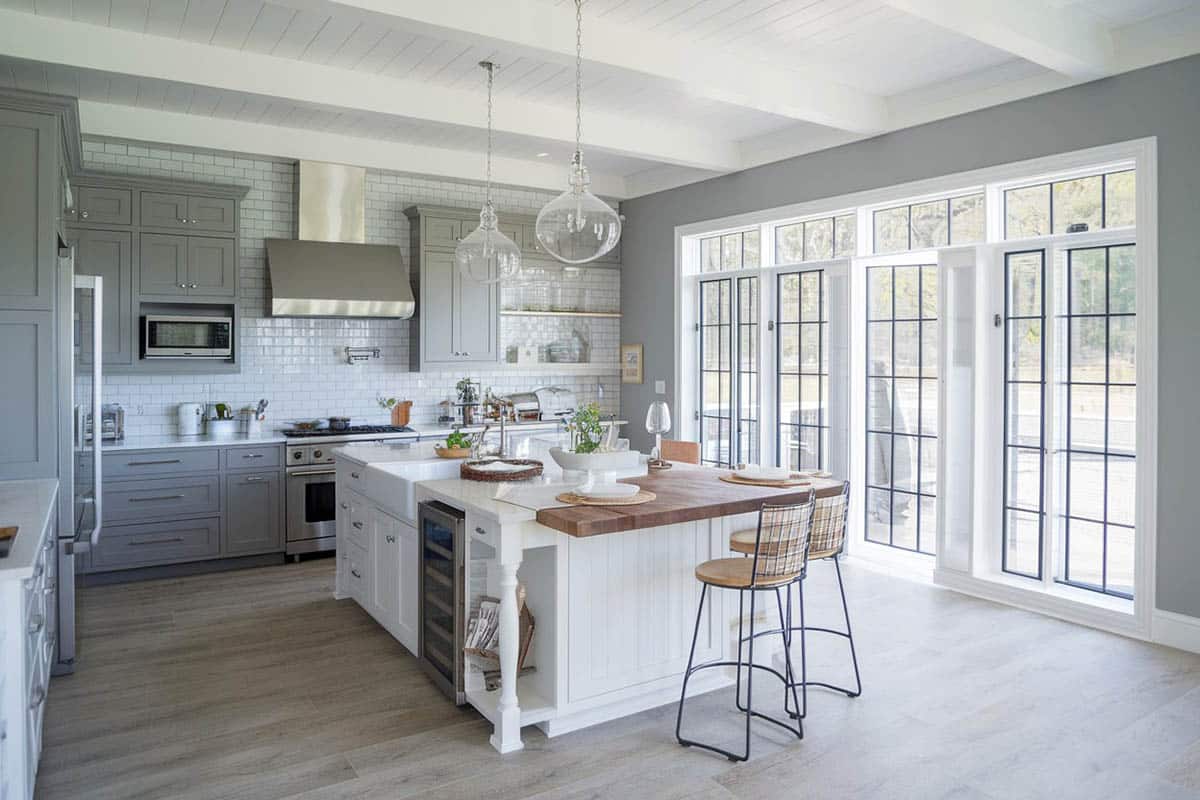 Traditional kitchen with two tone gray cabinetry, and white island