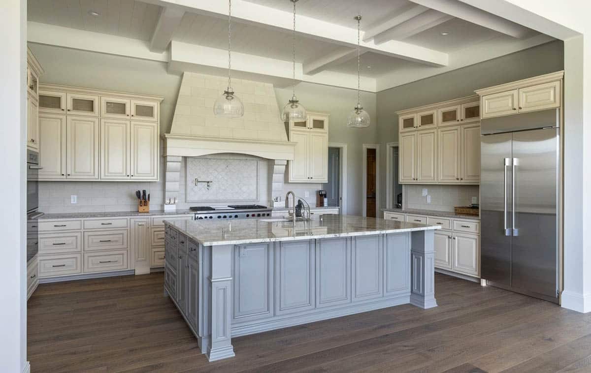 Traditional kitchen with off white cabinets and gray island and columns