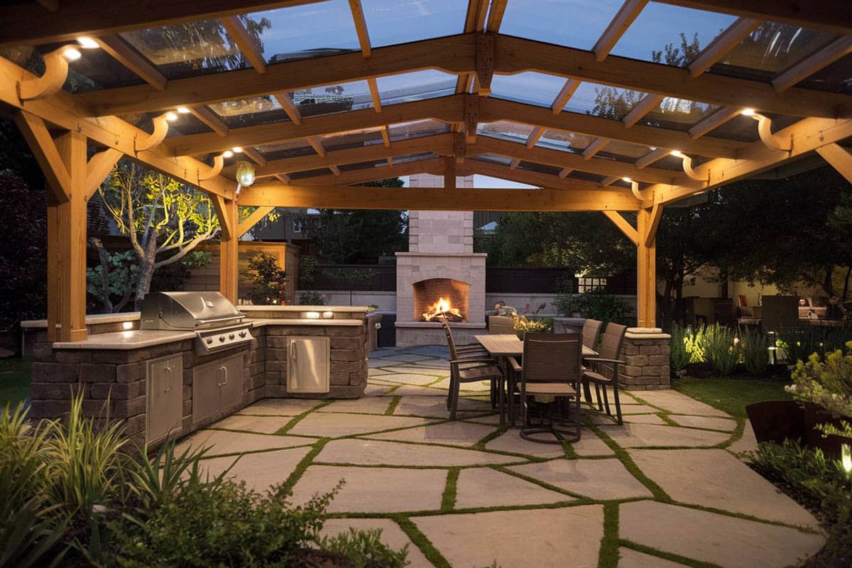 Pavilion with travertine tiles, grill, 6-seater dining furniture and fireplace