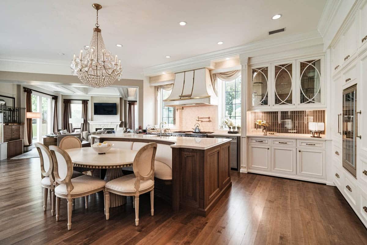 Beautiful kitchen with white flat panel cabinets and dark wood island with bench