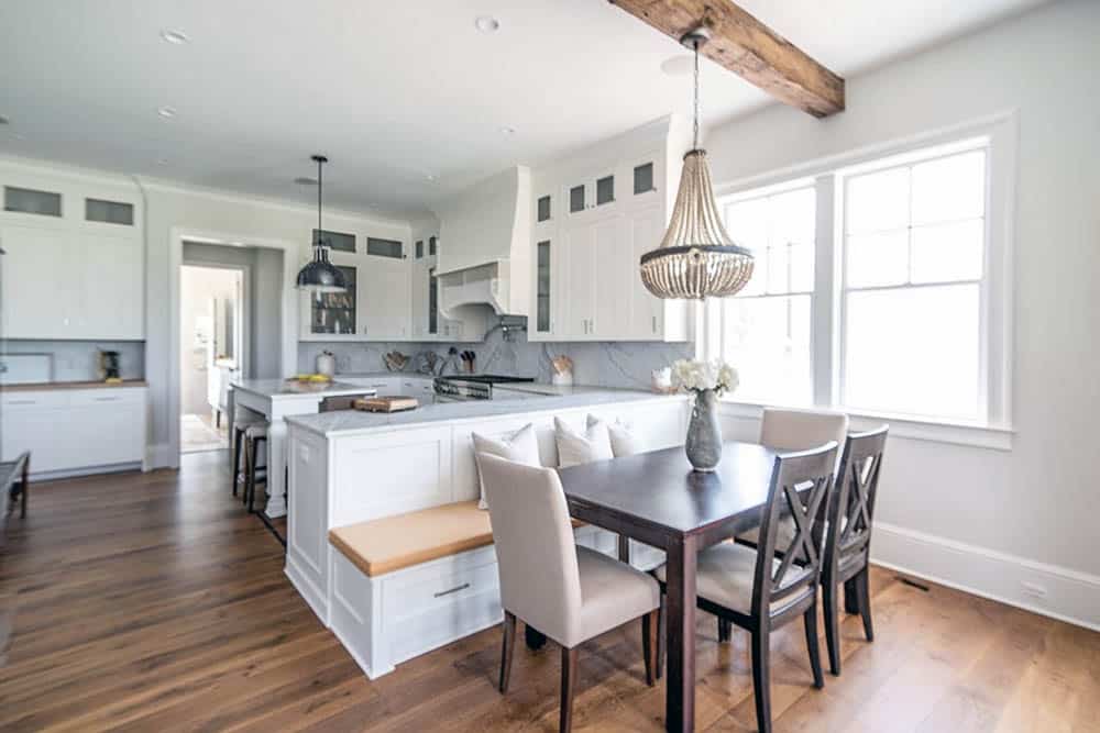 Kitchen with dining peninsula with built in bench seating next to rustic wood table
