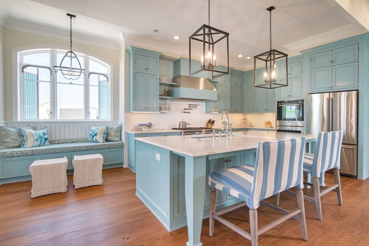 Beautiful cottage kitchen with aqua cabinets, breakfast bar island, white marble top counters and window seat bench