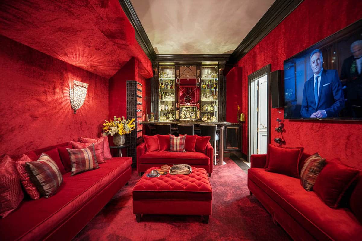 Plush red velvet media room with wide screen television and bar
