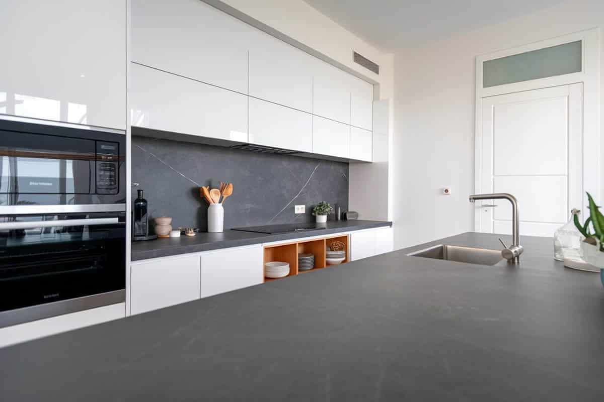 Modern kitchen with white cabinets and black leather finish quartz countertops