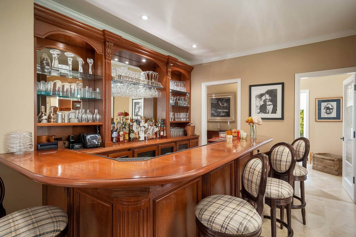 Room with polished wood counter, beige walls and glasses on shelves